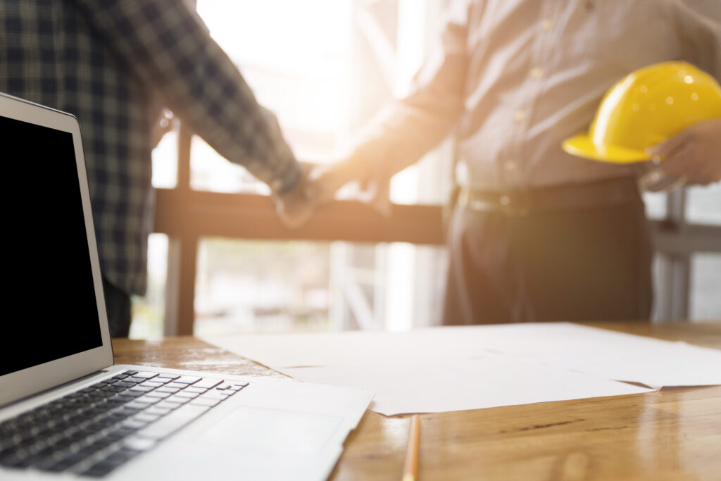 architect engineer shaking hands beside window - business teamwo